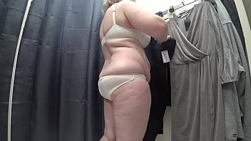 A Voluptuous Mature Woman With A Luscious Rear Barely Contained In Her White Panties And Ample Bosom Spilling From Her Bra Is Caught On Hidden Camera In A Public Changing Stall.
